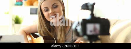 Young woman plays acoustic guitar and records video clips for social networks Stock Photo