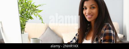 Positive afro business woman smiling at workplace at home Stock Photo