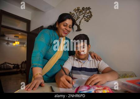Mother helping her son with homework at home Stock Photo