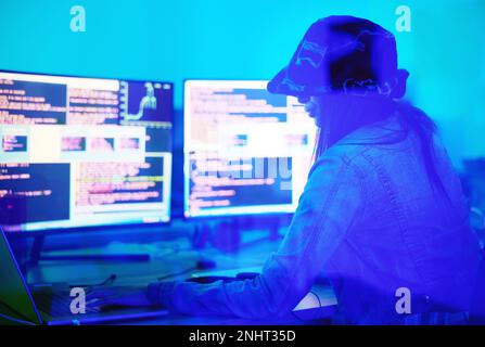 Hacker, programmer and woman typing on laptop in home at night in neon light to hack software. Cybersecurity, ransomware phishing and female coder Stock Photo