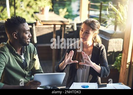 Developing a new design together. two designers having a meeting at a coffee shop. Stock Photo