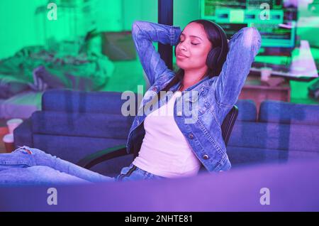 Woman, headphones or relax in neon house after technology coding, software development or cybersecurity safety. Happy, programmer or hands behind head Stock Photo