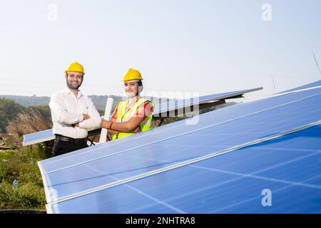 Portrait of Young indian woman technicians standing near solar panels.Industrial workers solar system installation, alternative renewable green energy Stock Photo