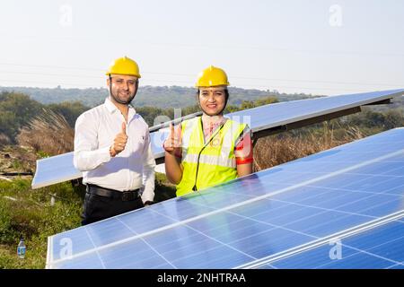 Portrait of Young indian woman technicians standing near solar panels.Industrial workers solar system installation, alternative renewable green energy Stock Photo
