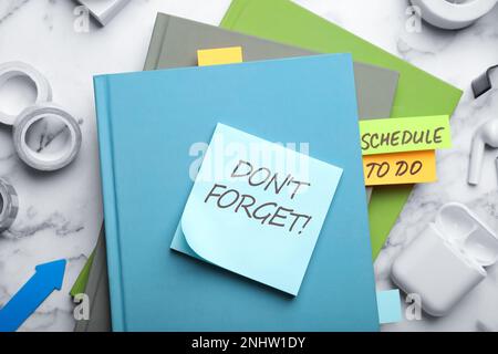 Reminder note with text DON'T FORGET and stationery on white marble table, flat lay Stock Photo