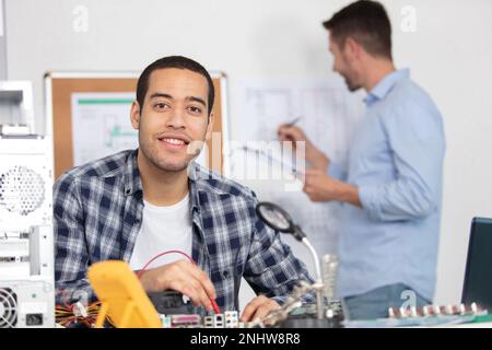 electronic engineers check digital multimeter indicators Stock Photo