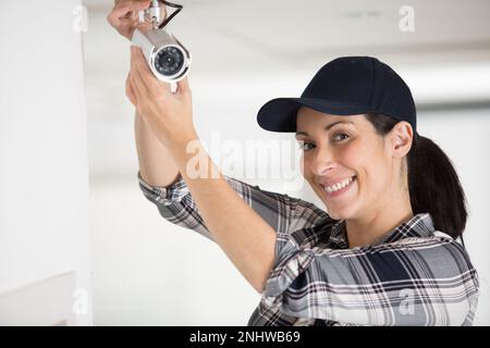 female worker installing cctv camera Stock Photo