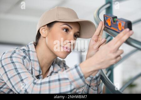 portrait of female contractor using spirit level Stock Photo