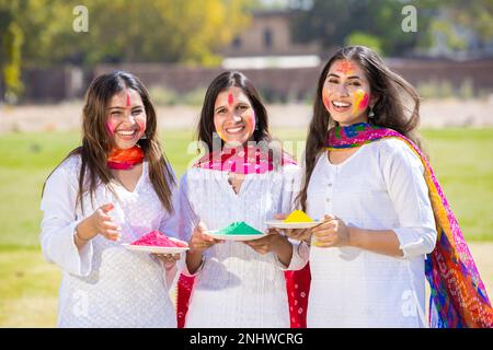 Group of happy indian friends wearing white kurta dress holding