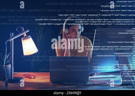 Programmer with headphones working in office at night Stock Photo