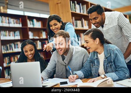 Theyre enjoying their study session. a group of university students studying in the library. Stock Photo