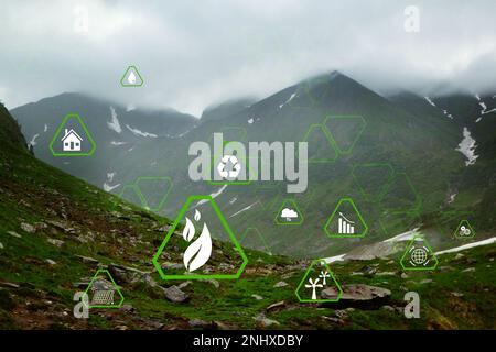 Digital eco icons and beautiful mountains on cloudy day Stock Photo