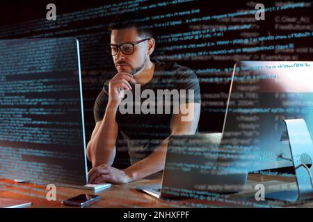 Programmer working in modern office at night Stock Photo