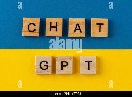ChatGPT background. Words in wooden letters. Chat with AI or Artificial Intelligence by OpenAI. Phrase on a blue and yellow. Ukraine color Stock Photo
