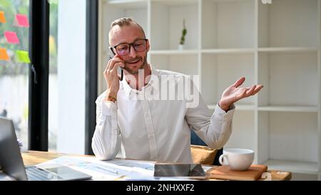 Professional and smart Caucasian businessman or male financial consultant on the phone with business client, counseling and dealing business over the Stock Photo