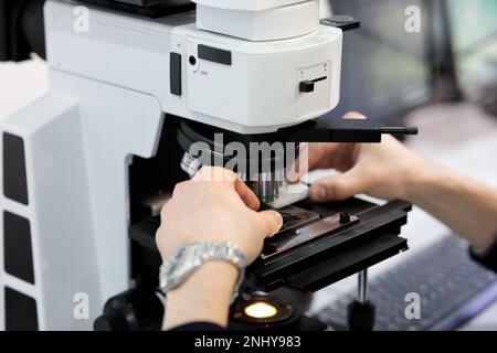 Scientist working with optical microscope in laboratory. Selective focus. Stock Photo