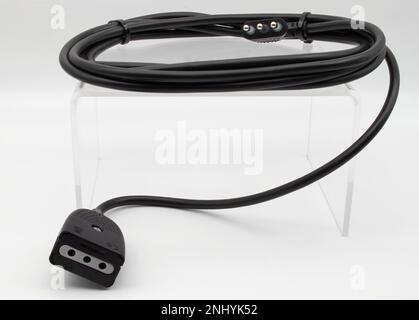 Black electric power extension cable on display isolated on white background. Stock Photo