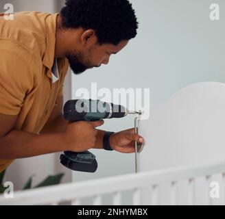 Installation, drill and man building a crib while preparing for his new baby in the family home. Engineering, metal and African father doing Stock Photo