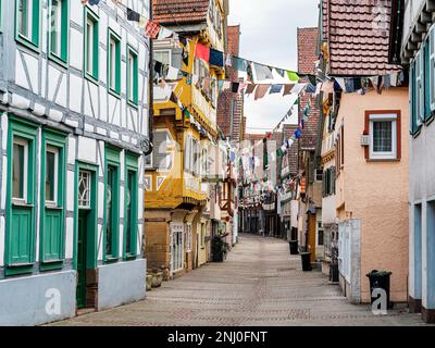 Half-timbered houses with colorful scraps of cloth on clotheslines as a tradition for carnival in the city center of the Swabian town of Herrenberg Stock Photo