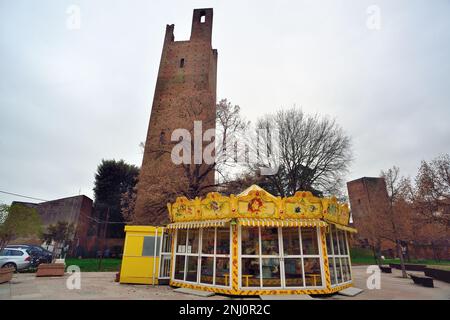 Rovigo, Italy. Donà tower L and Grimani tower or Mozza tower R. the two medieval towers were part of the ancient city walls. In the foreground, a carousel for children. Stock Photo
