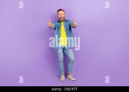 Full length photo of handsome granddad showing double thumb up excited wear trendy jeans clothes isolated on yellow color background Stock Photo