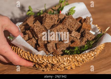 Homemade black rye cereal bread in a wicker basket in a traditional street food market, close up Stock Photo