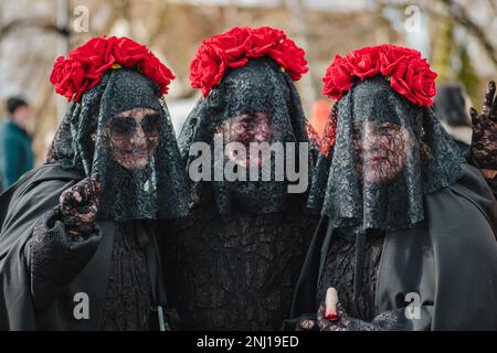 Three girls or women dressing in black with roses like widows during Uzgavenes, a Lithuanian folk festival during Carnival, seventh week before Easter Stock Photo