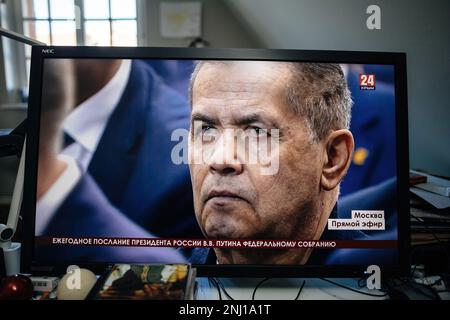 Paris, France - Feb 21, 2023: Computer display streaming PC Krym 24 station with russian state men listens as Russian President Vladimir Putin speaks during his annual meeting with the Federal Assembly Stock Photo