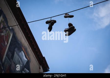 Shoes hanging from telephone wire Stock Photo