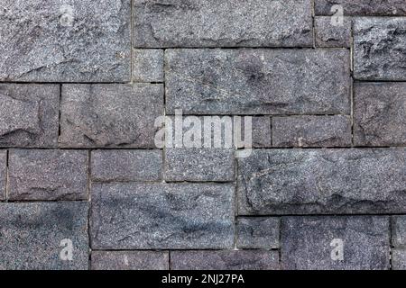 Old gray wall made of rough granite blocks. Close up background photo texture Stock Photo