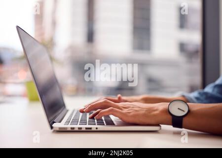 Close Up Of Businesswoman In Modern Office Working On Laptop Stock Photo