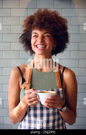 Portrait Of Smiling Female Owner Or Staff Inside Shop Or Cafe Holding Hot Drink Stock Photo
