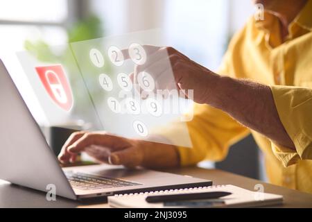 Online Security Concept With Man Using Laptop With Graphic Overlay Of Lock And PIN Number Keypad Stock Photo