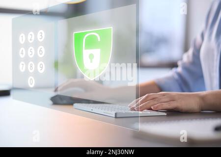 Online Security Concept With Woman Using Laptop With Graphic Overlay Of Lock And PIN Number Keypad Stock Photo