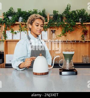Female barista at the counter with a kettle. Young woman making coffee with a filter. Stock Photo