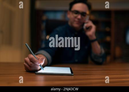 Young man wearing glasses graphic designer working late at night Stock Photo