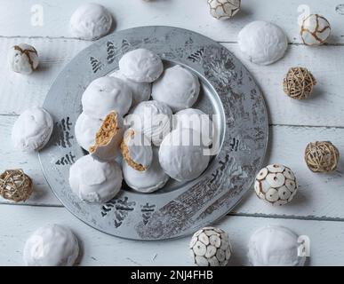 Christmas gingerbread cookies with egg white icing on a silver plate on white background with decoration Stock Photo