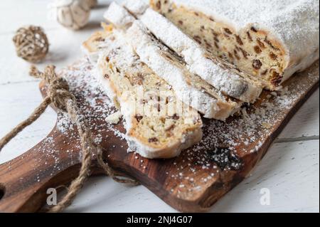 Loaf of fruit bread or fruit cake. Traditonal german christmas Stollen with candied fruits, raisins and nuts. Coated with powdered sugar. Stock Photo