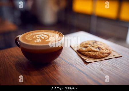 Close Up Of Decorated Coffee And Cookie On Table In Coffee Shop Stock Photo