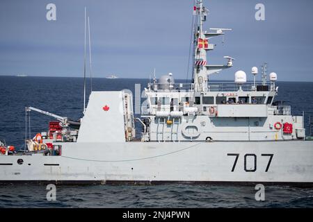 Royal Canadian Navy sailors aboard HMCS Goose Bay glance from their bridge toward USCGC Bear (WMEC 901) during a refueling at sea exercise, Northern Atlantic Ocean, Aug. 5, 2022. The Bear is participating in the Tuugaalik phase of Operation Nanook, an annual exercise that allows the United States and multiple other partner nations to ensure security and enhance interoperability in Arctic waters. Stock Photo