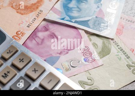 Calculator standing on 10, 20, 50, 100 and 200 Turkish lira or TL banknotes Stock Photo