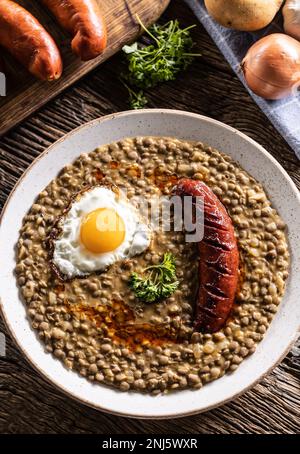 Lentil stew with baked sausageand egg, traditional Slovak food - Top of view. Stock Photo