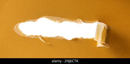 golden ripped paper with white hole. copy space Stock Photo