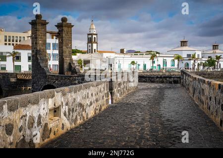 Puente de Las Bolas bridge, in backgrount, bell tower of church San Gines and town hall,  Lanzarote, spain Stock Photo