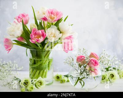 Beautiful flowers bouquet in vase on the wooden table.Tulips,roses and eustoma. Stock Photo