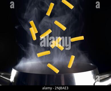 macaroni falling in to the pot Stock Photo