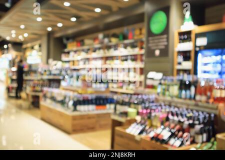 Abstract blur wine bottles on liquor alcohol shelves in supermarket or wine store background Stock Photo