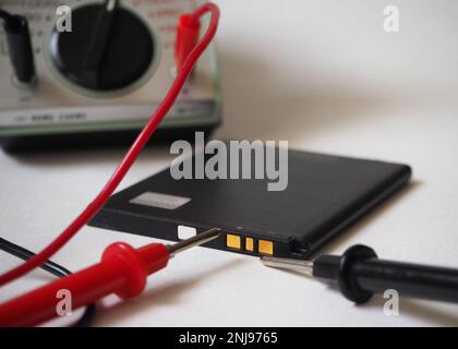 Battery condition test with voltmeter on a white background. Stock Photo