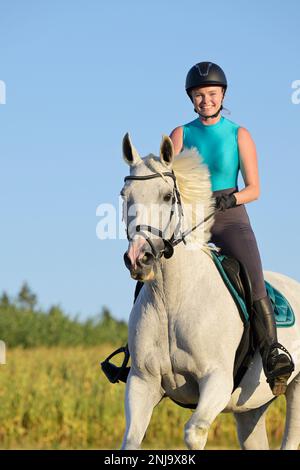Horseback rider on a Polish horse galloping in a stubble field Stock Photo