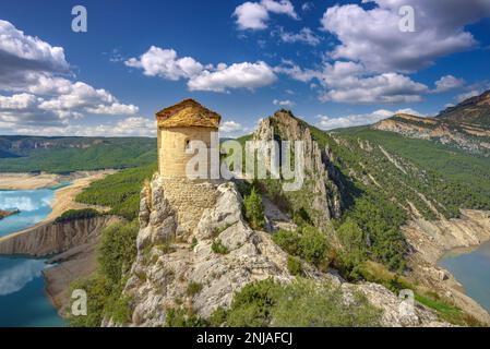 Hermitage of La Pertusa on a cliff above the Canelles reservoir with very little water during the 2022 drought (La Noguera, Lleida, Catalonia, Spain) Stock Photo